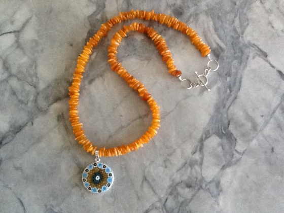 Murano millefiori disc bezeled in sterling silver, with Baltic amber chips and sterling silver clasp; 18.5” to 19” adjustable length.  Priced at $99 including shipping and insurance. 